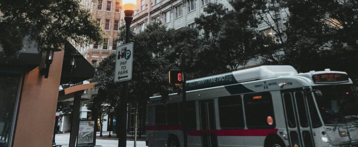 Urban scene with a bus and tall buildings in the background.