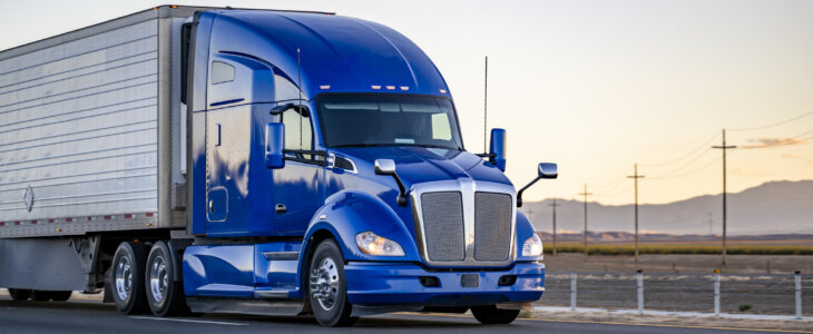 semi truck transporting cargo in reefer semi trailer driving on the road with sunset